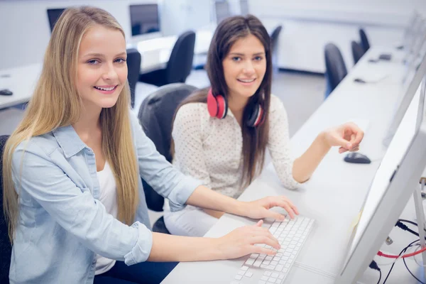 Estudantes sorrindo usando o computador — Fotografia de Stock