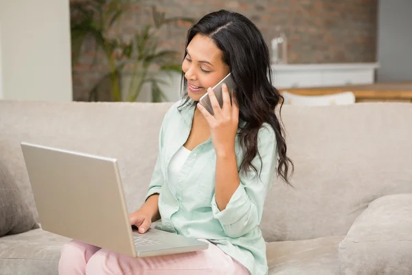 Morena no telefonema usando laptop — Fotografia de Stock