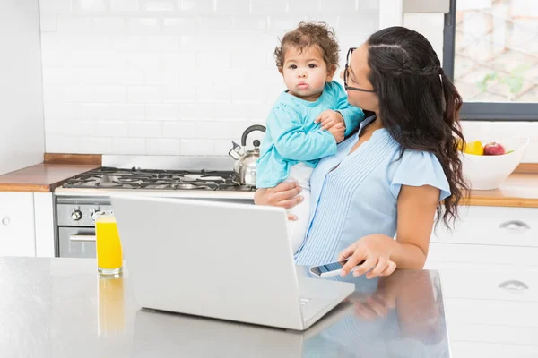 Morena sorridente segurando seu bebê — Fotografia de Stock