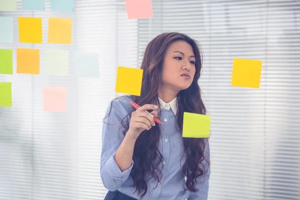 Asiatique femme d'affaires en utilisant des notes collantes — Photo