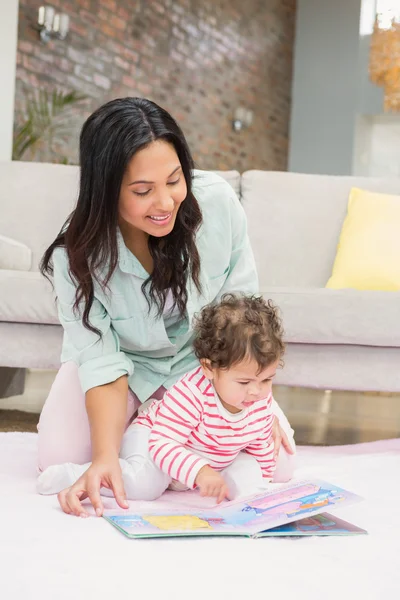 Mamma med barn tittar på bok — Stockfoto