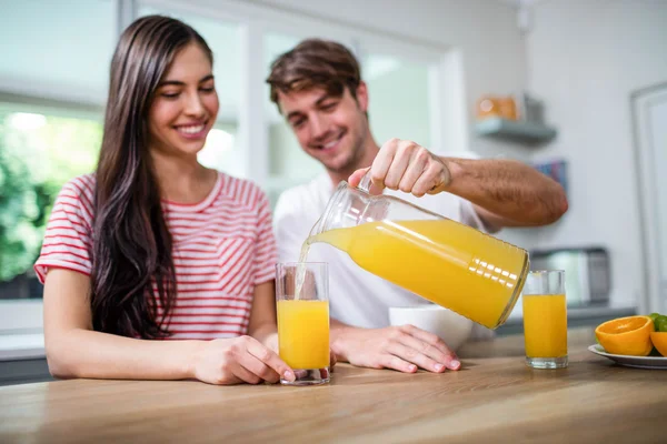 Человек наливает апельсиновый сок в стекло — стоковое фото