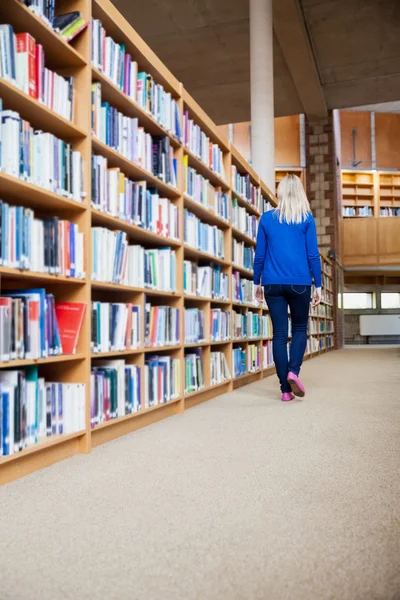 Female student walking in library — Stock Photo, Image