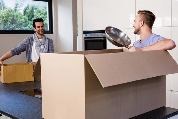 Gay couple unpacking cardboard — Stock Photo, Image