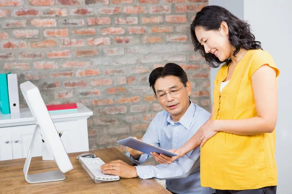 Pregnant woman showing tablet to husband — Stock Photo, Image