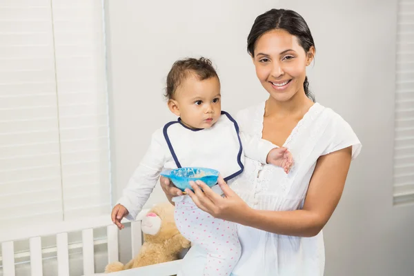 Smiling brunette feeding baby — Stock Photo, Image