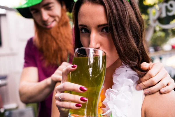 Mulher disfarçada segurando cerveja verde — Fotografia de Stock