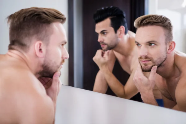 Hombres no sonrientes frente al espejo — Foto de Stock