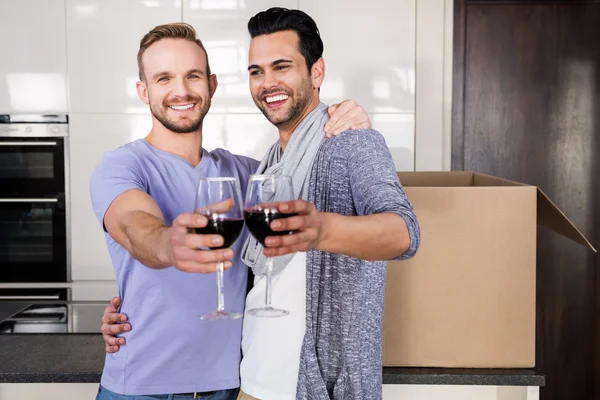 Gay couple toasting with red wine — Stock Photo, Image