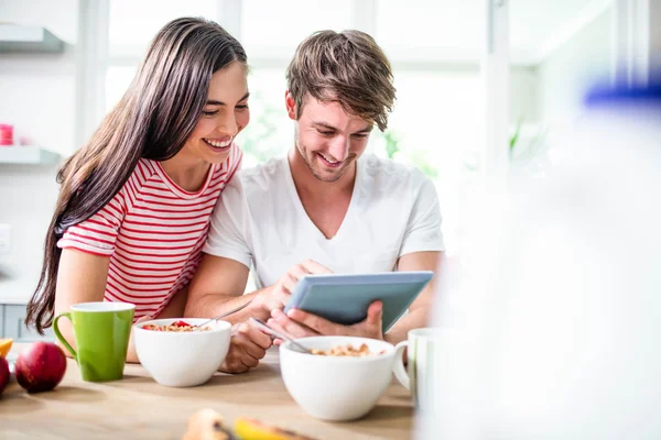 Pareja usando la tableta y desayunando —  Fotos de Stock