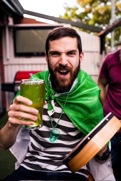 Disfarçado homem segurando cerveja verde — Fotografia de Stock