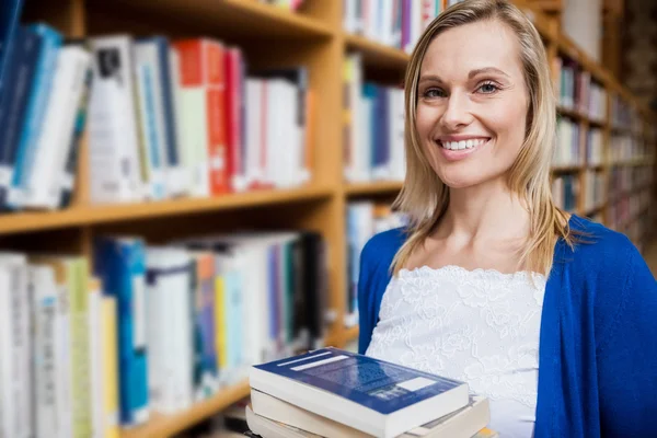Kvinnlig student som böcker i biblioteket — Stockfoto