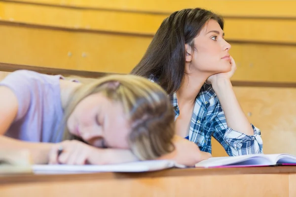 Estudiante aburrido escuchando mientras duerme compañero de clase — Foto de Stock
