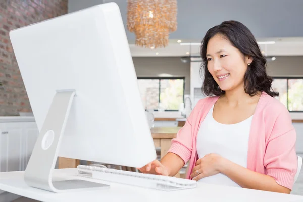 Mulher sorrindo usando o computador — Fotografia de Stock