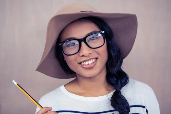 Mulher asiática com chapéu segurando lápis — Fotografia de Stock