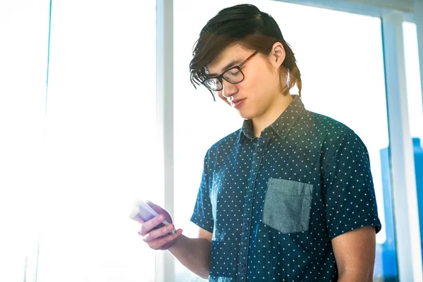 Smiling hipster using his phone — Stock Photo, Image