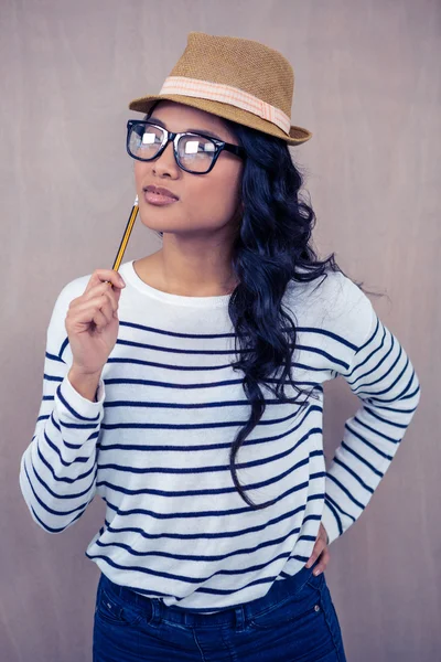 Mulher asiática atraente com chapéu segurando lápis — Fotografia de Stock