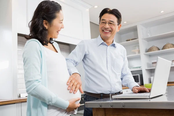 Expectant couple using laptop — Stockfoto