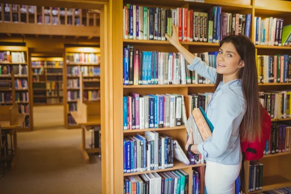 Brünette Studentin sucht sich Buch aus — Stockfoto