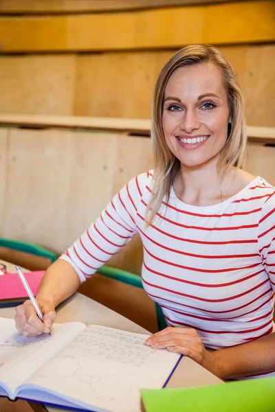 Happy kvinnlig student skriver anteckningar — Stockfoto