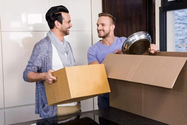 Gay couple unpacking cardboard — Stock Photo, Image