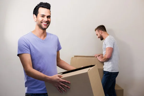 Feliz gay casal segurando caixas — Fotografia de Stock