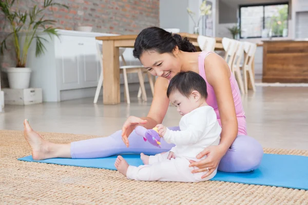 Mother and baby daughter on exercising mat — Stockfoto