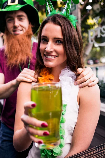 Mulher disfarçada segurando cerveja verde — Fotografia de Stock