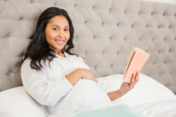 Morena grávida lendo um livro — Fotografia de Stock