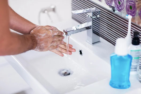 Akan suyun altında yıkama elinde — Stok fotoğraf