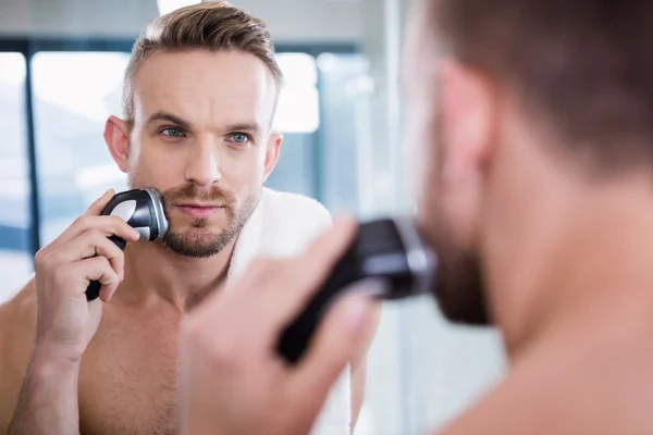 Concentrated man shaving his beard — Stock Photo, Image