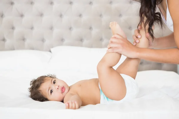 Morena brincando com pernas de bebê — Fotografia de Stock