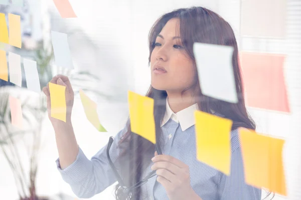 Mujer de negocios asiática usando notas adhesivas — Foto de Stock