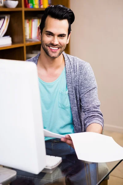 Lächelnder Designer beim Lesen von Dokumenten — Stockfoto