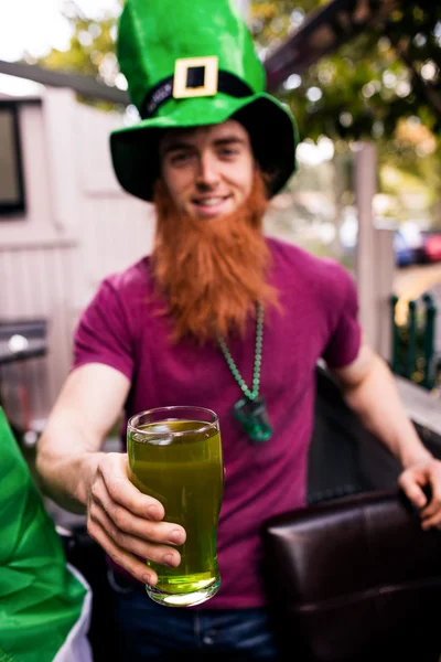 Disfarçado homem segurando cerveja verde — Fotografia de Stock