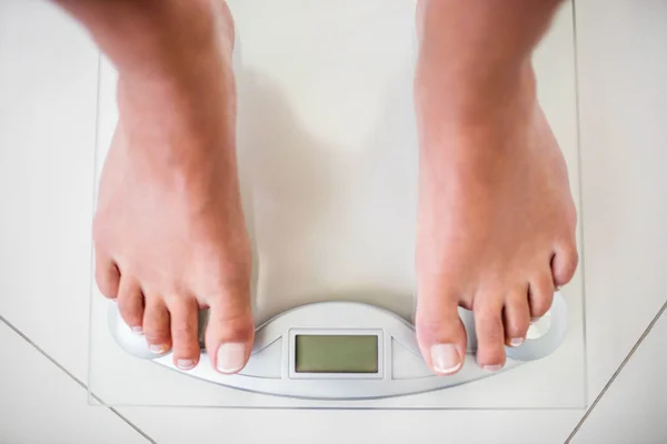 Piedi di donna su scala di ponderazione — Foto Stock