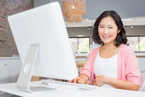 Sorrindo mulher grávida usando computador — Fotografia de Stock