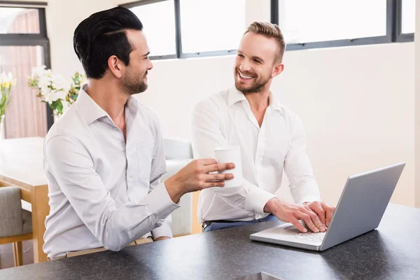 Smiling gay couple using laptop — Stock Photo, Image