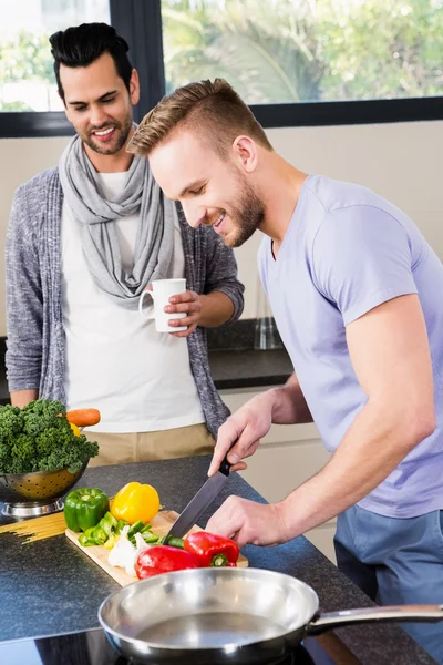 Улыбающаяся гей-пара готовит еду — стоковое фото