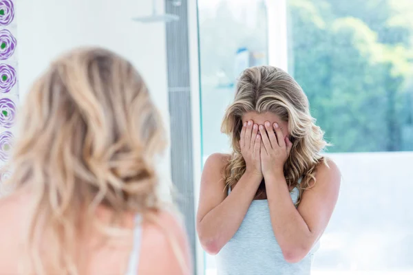 Vrouw kijken naar zichzelf in de badkamer — Stockfoto