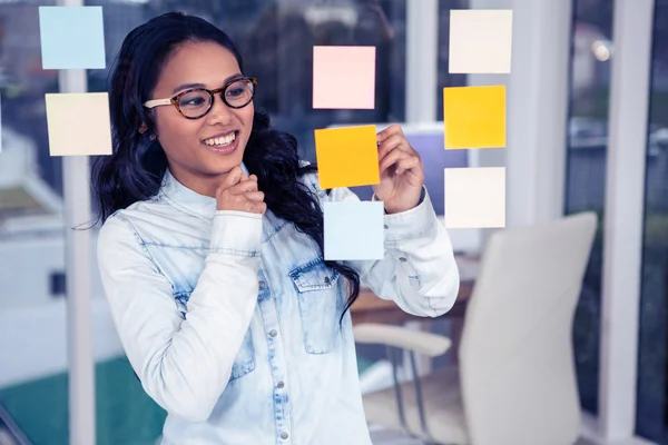 Mujer asiática mirando notas pegajosas —  Fotos de Stock