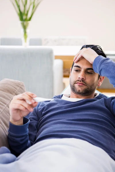 Kranker Mann überprüft seine Temperatur — Stockfoto