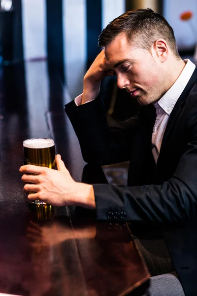 Thoughtful businessman having beer — Stock Photo, Image