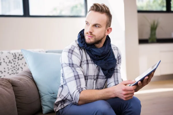 Handsome man using tablet on couch — Stock Photo, Image