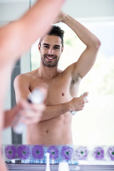 Мужчина без рубашки кладет дезодорант — стоковое фото