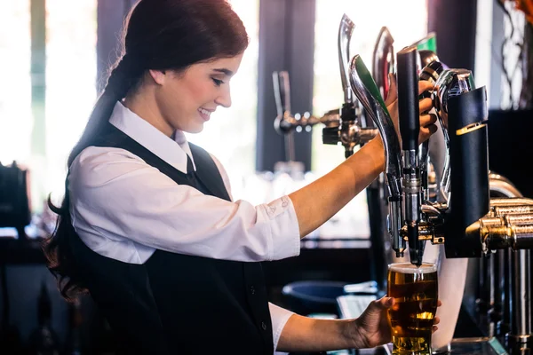 Barmanka sloužící pivo — Stock fotografie