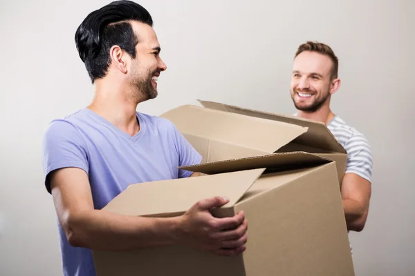 Feliz gay casal segurando caixas — Fotografia de Stock