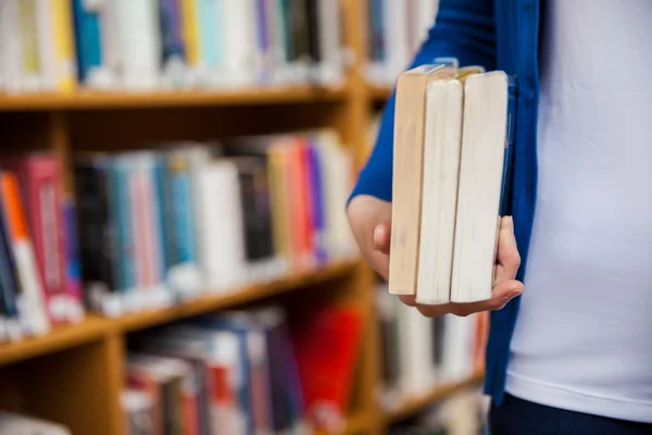 Kvinnlig student som böcker i biblioteket — Stockfoto