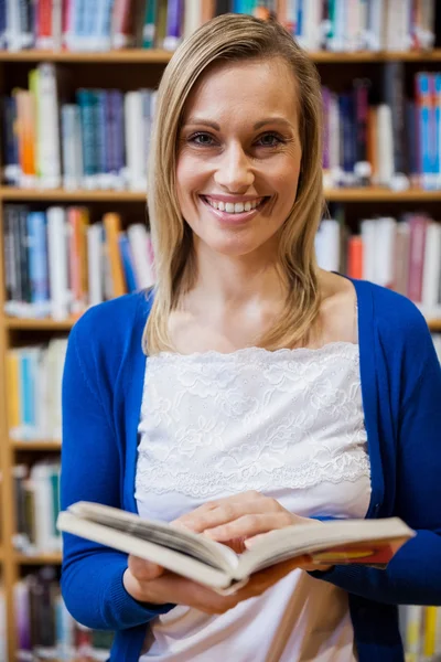 Female student reading book in library — Stock Photo, Image