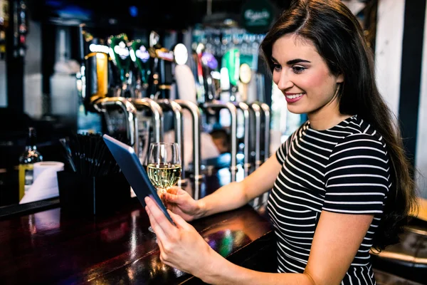 Mulher a utilizar comprimido e a beber vinho — Fotografia de Stock